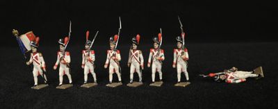sept petits soldats alignés les uns à côté des autres sur une surface noire