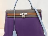 un sac à main violet et gris muni d'un cadenas sur la poignée