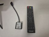 a remote control sitting next to a pen on a table