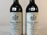 deux bouteilles de vin rouge posées sur une table blanche
