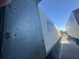 two semi trucks that are parked on the side of the road