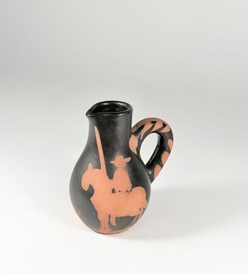 vase noir et orange posé sur une surface blanche, sur fond blanc