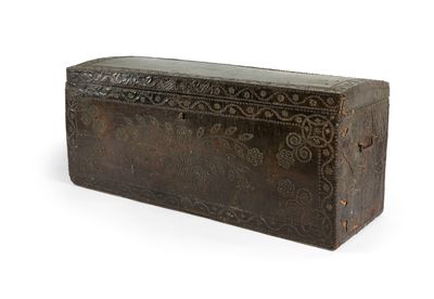 une vieille malle posée sur une surface blanche