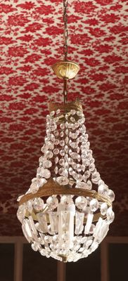 a chandelier hanging from a ceiling with a red and white wallpaper