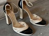 black and white high heeled shoes with laces on the toes