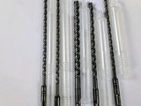 four black and white straws are lined up on a white table