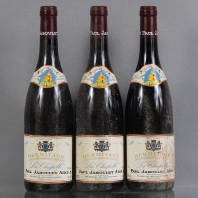 three bottles of wine are lined up on a table