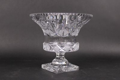une image représentant un vase en verre transparent posé sur une surface noire
