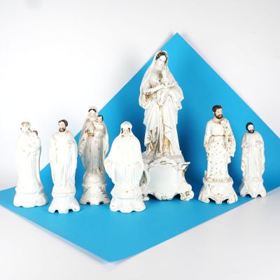 des figurines représentant un groupe de personnes vêtues de blanc sur fond bleu