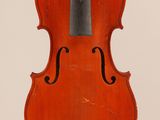 un vieux violon posé sur une surface blanche