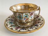 a cup and saucer on a saucer on a white table