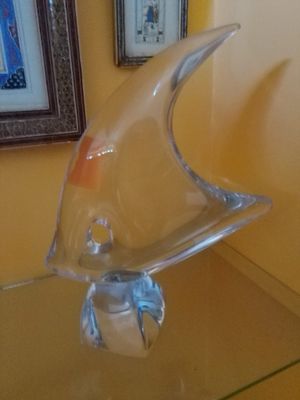 une sculpture en verre représentant un poisson, posée sur une table en verre