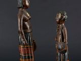 two wooden figures of a man and a woman standing next to each other