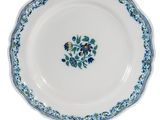 un gros plan d'une assiette blanche ornée de fleurs bleues et vertes