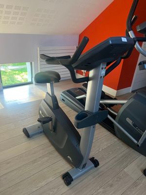 a gym room with a tread machine and a window