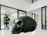 a sculpture of a skull sitting on a table in a room