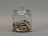 a glass jar filled with donuts covered in powdered sugar