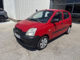 La petite voiture rouge est garée devant un immeuble.