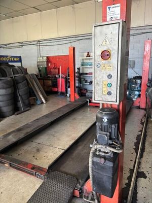 une photo d'un garage où l'on voit de nombreux pneus par terre