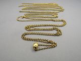 a close up of a gold chain with a skull on it