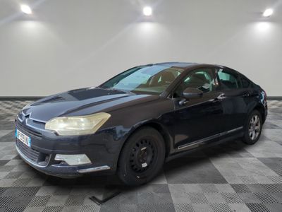 the black car is parked in the garage on the checkered floor