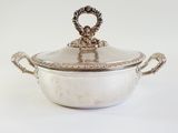 an antique silver plated casserole with a lid and handles