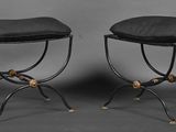 paire de tabourets en fer forgé noir avec des coussins noirs