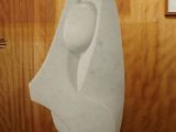 a white sculpture on a table in front of a wooden wall