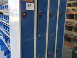 blue lockers in a warehouse with a lot of shelves and bins in the background