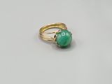 a close up of a ring with a green stone on it