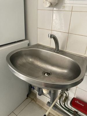 un évier et un réfrigérateur dans une petite pièce