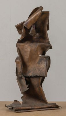 des sculptures en métal posées sur une table en bois, devant un mur blanc
