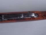 an old rifle is laying on a white surface with a wooden handle