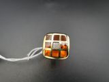 perle de verre jaune et marron montée sur un fil blanc, posée sur une surface noire