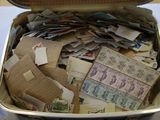 a suitcase full of mail and stamps on a table