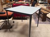 a table and chair in a room with a lot of furniture