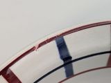 a white bowl with red and blue stripes on it
