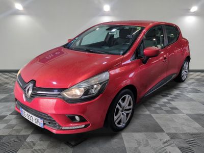 a red car is parked in a room with a checkered floor