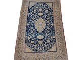 un tapis persan ancien, avec une bordure bleue et un motif floral