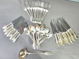 a lot of silver spoons and spoons on the table