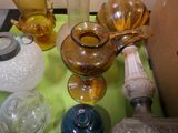 many different colored glass vases on a green table