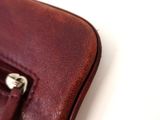 a close up of a brown leather bag on a white surface