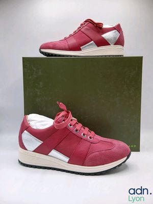 a pair of red and white sneakers sitting on top of a box