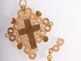 an image of a gold cross and a pair of earrings on a white surface