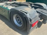 a green semi truck parked in a parking lot