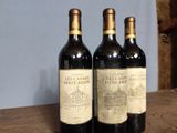 three bottles of wine sitting on top of a wooden table