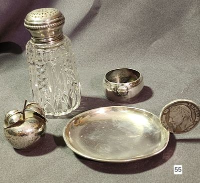 a silver plate and a silver salt shaker on a table