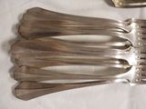 five forks and a spoon sitting on a table