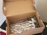 a box full of coins sitting on top of a pile of books