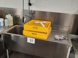 a sink with a yellow basket in it in a kitchen